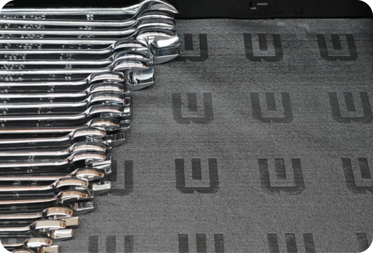 Set of wrenches on a gray mat with a brand logo